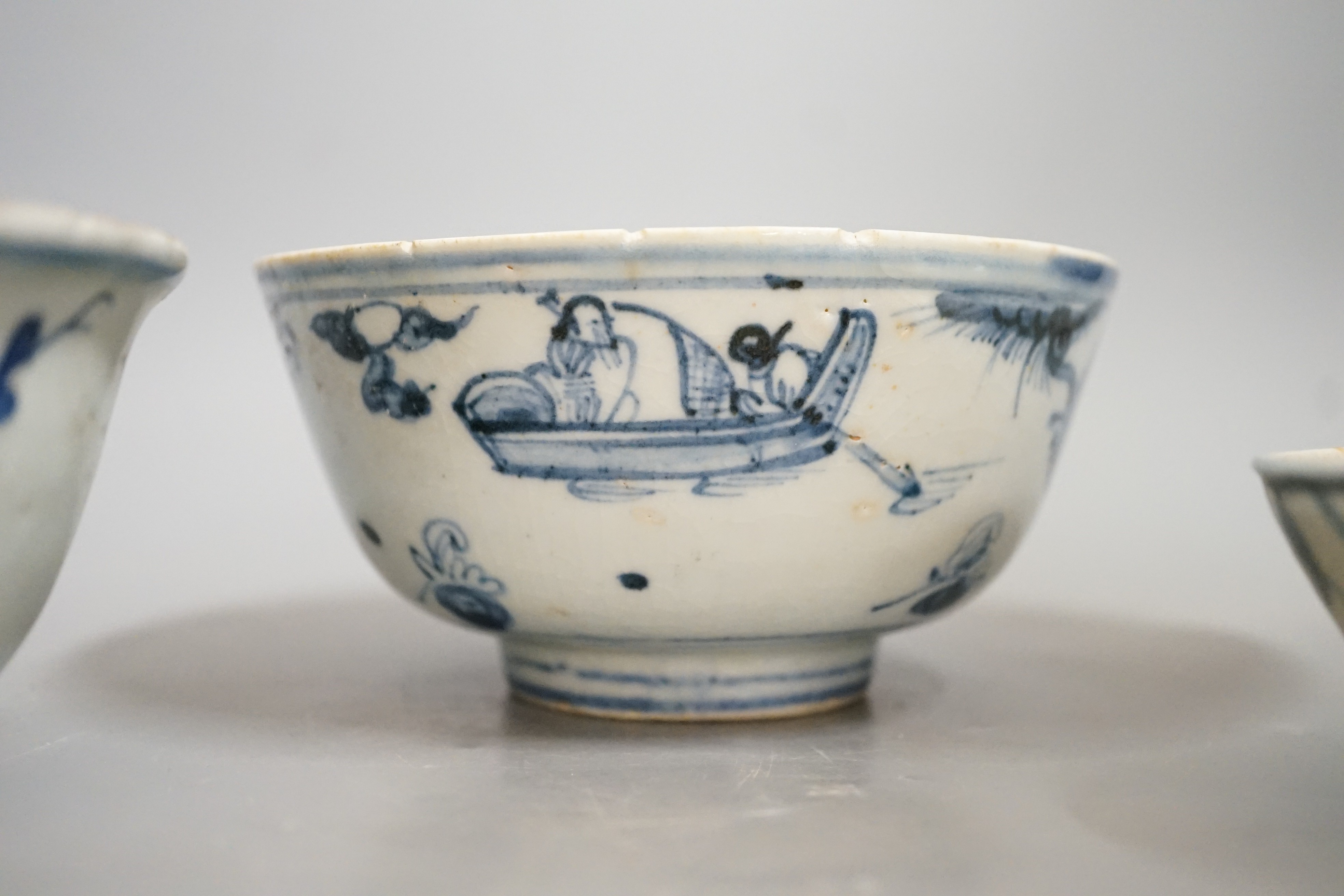 Three Chinese late Ming blue and white bowls, one painted with figures in a boat on horseback and in the landscape, the second with floral sprays, with ‘Made in the Great Ming dynasty’ mark and another bowl, largest 13.3